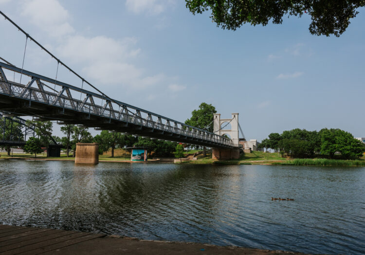 view of Brazos River with Waco Suspension Bridge in the background